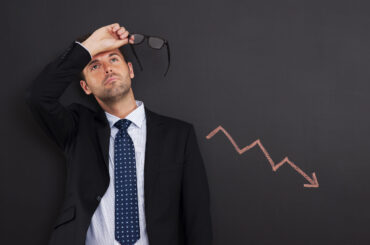 Worried trader with sign of decreased profit