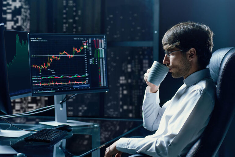 financial analyst with a cup of coffee working on the trading situation