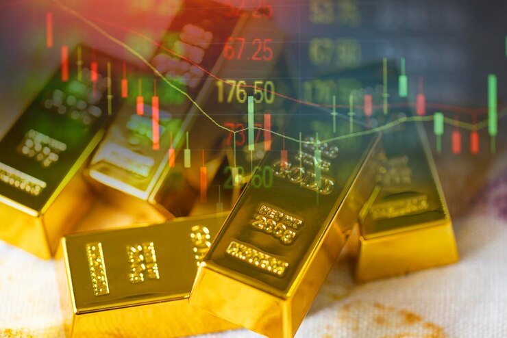 A photo showcasing gold trading with gold bars placed on a fabric background, accompanied by a stock graph chart in the stock market trade.