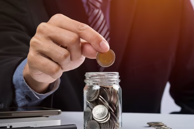 Investments, a business man is saving coins in a jar.