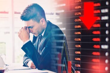 A trader exhibiting signs of distress while viewing a falling financial market chart, illustrating the risks of overleveraging in trading.