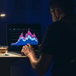 A professional trader analyzing technical analysis stock charts on a laptop in a dark room, focusing on market structure and liquidity zones.