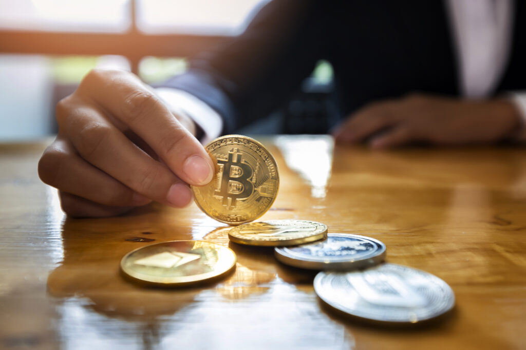 Close-up of a businesswoman holding a physical golden Bitcoin coin, representing Bitcoin's market share and its influence on altcoin trading strategies.