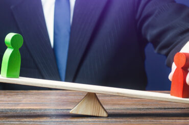 Businessman balancing red and green figures on a seesaw representing market imbalance and price rebalancing in Fair Value Gap trading