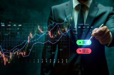 Business professional in a suit using a digital trading interface with candlestick charts, trend lines, and buy/sell buttons, representing trading indicators vs price action strategies in financial markets.