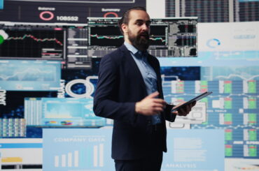Professional trader presenting best strategies for commodity trading with market data and charts on display screens