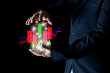 Trader controlling position sizing forex with candlestick charts and risk management indicators in hands