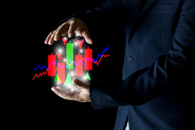 Trader controlling position sizing forex with candlestick charts and risk management indicators in hands