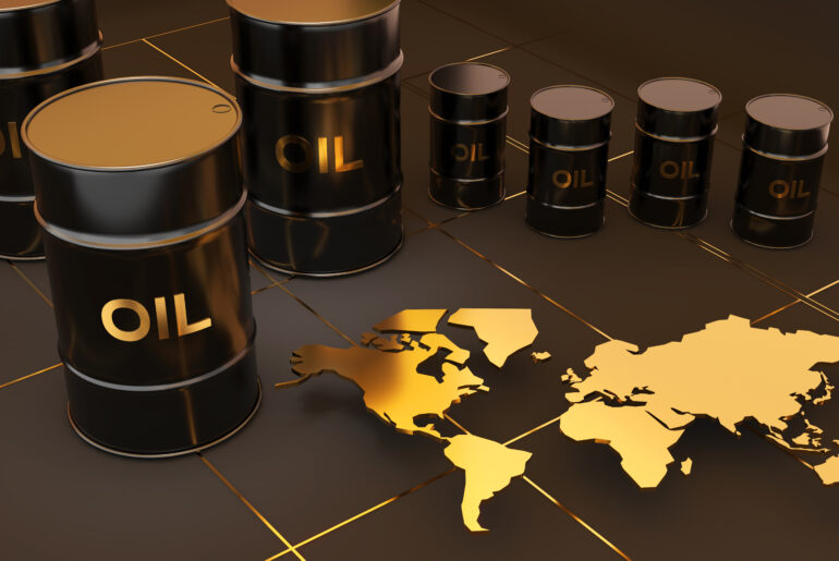 Black crude oil barrels arranged next to a gold world map representing the Brent Crude Oil global benchmark.
