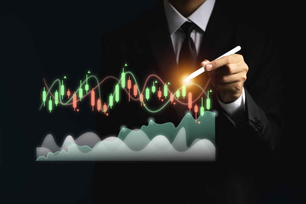 Businessman in a suit using a stylus pen to analyze financial candlestick charts and market trends for cross-asset trading