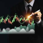 Businessman in a suit using a stylus pen to analyze financial candlestick charts and market trends for cross-asset trading