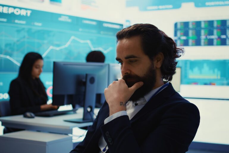 Financial analyst reviewing economic data charts to understand why markets rise on bad economic news.